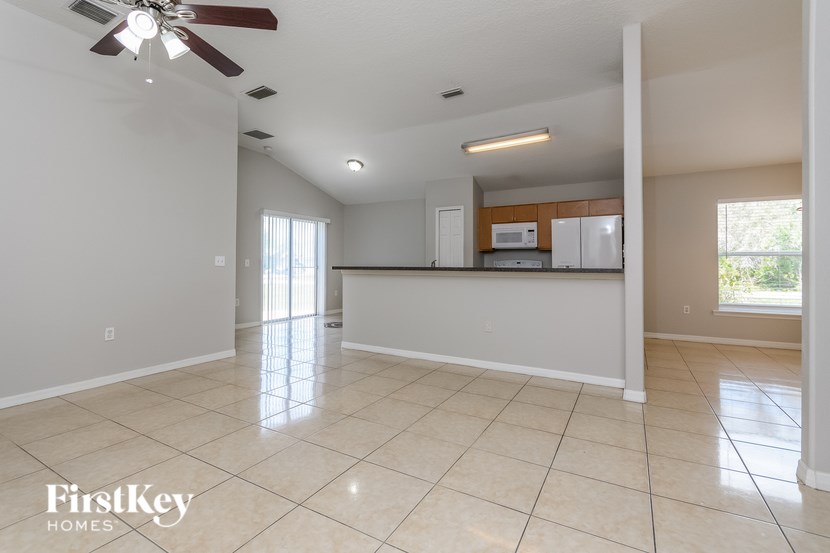 A spacious room with a fan and tiled flooring.