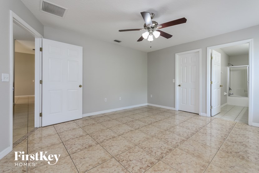 A spacious room with a ceiling fan and tile flooring.