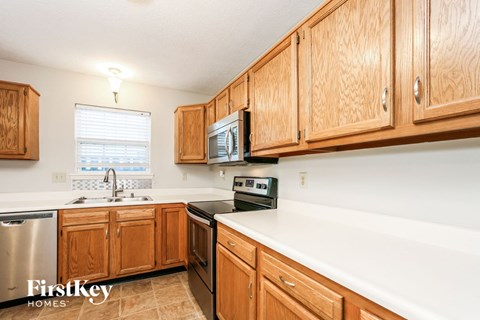 A kitchen with wooden cabinets and a stainless steel dishwasher.
