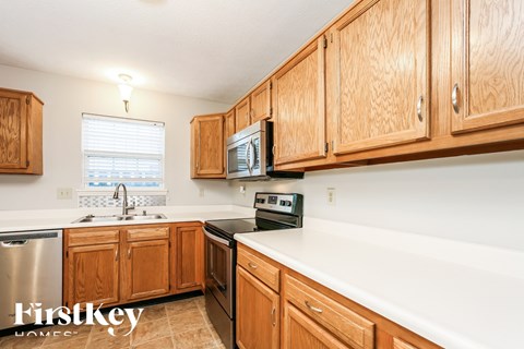 A kitchen with wooden cabinets and a stainless steel dishwasher.