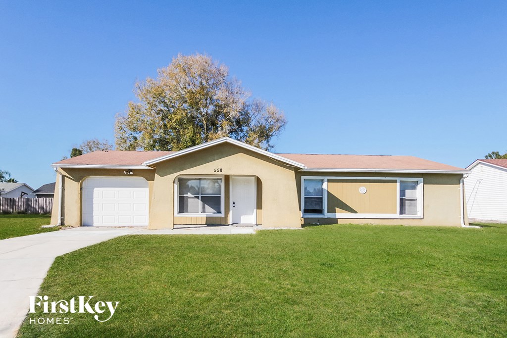 a beige house with a lawn in front of it