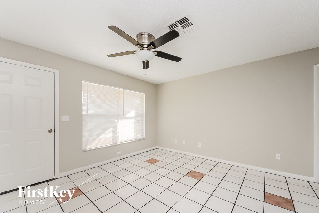 the living room has a ceiling fan and a tiled floor
