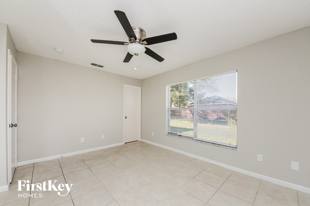 the living room has a large window and a ceiling fan