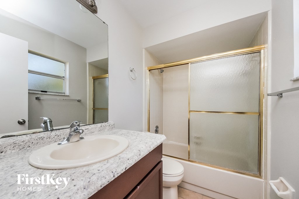 a bathroom with a sink and a shower and a toilet
