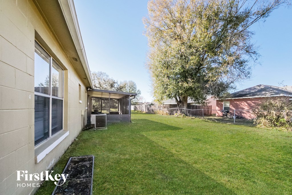 the backyard of a house with a yard and a chain link fence