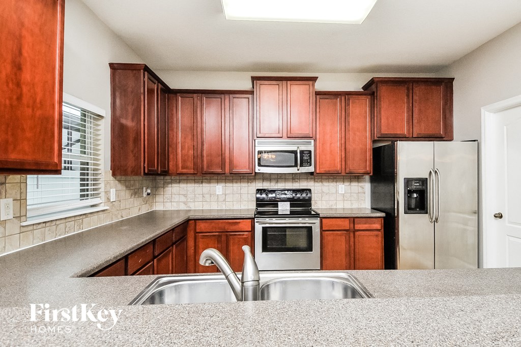 a kitchen with wooden cabinets and stainless steel appliances