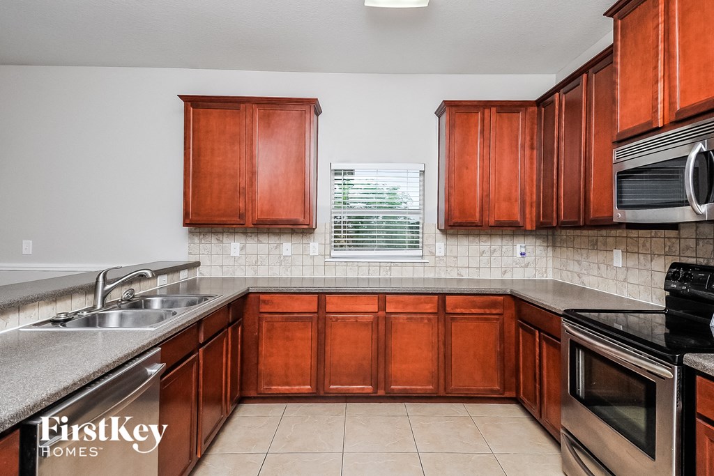 a kitchen with wooden cabinets and stainless steel appliances and a sink