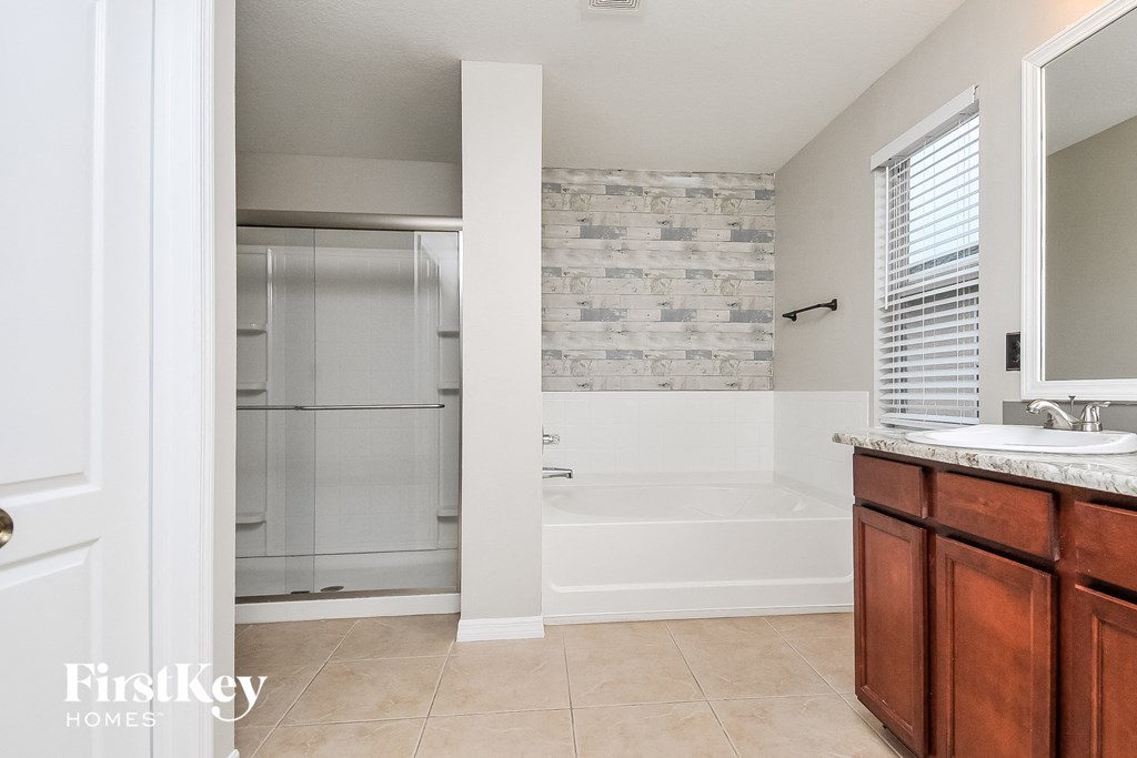 a bathroom with a tub and a sink and a shower