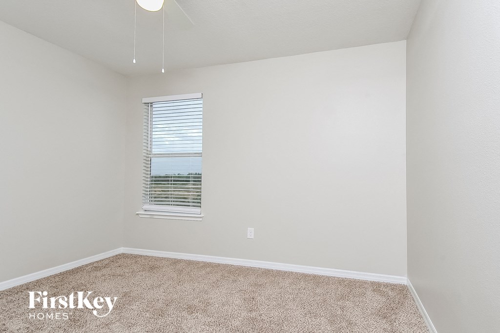 a spacious room with carpet and a window