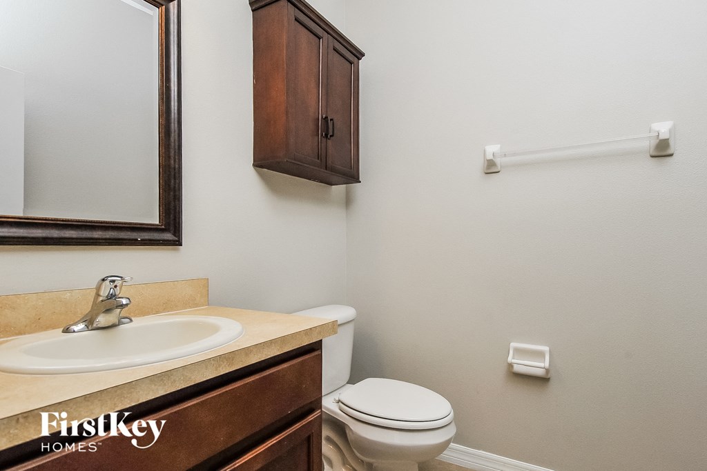 a bathroom with a toilet and a sink and a mirror
