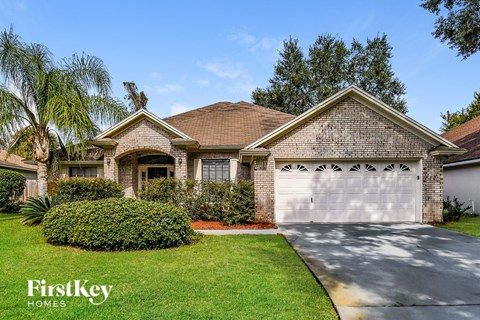 a small brick house with a white garage door in front of it