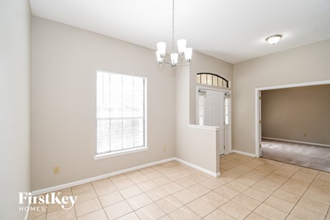 the living room and dining room are spacious and lighted by a chandelier