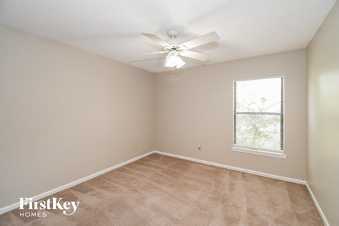 a bedroom with a ceiling fan and a window