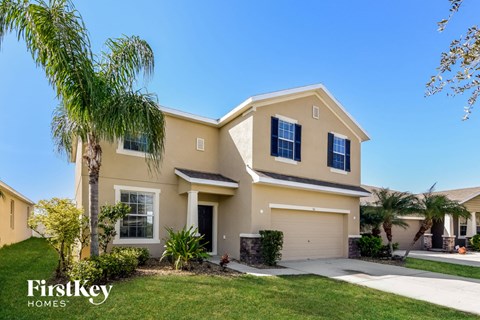a yellow house with a palm tree in front of it