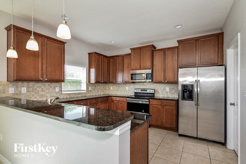 a kitchen with wooden cabinets and granite counter tops and stainless steel appliances