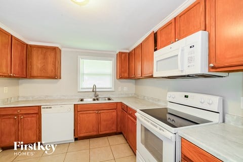 A kitchen with wooden cabinets and white appliances.