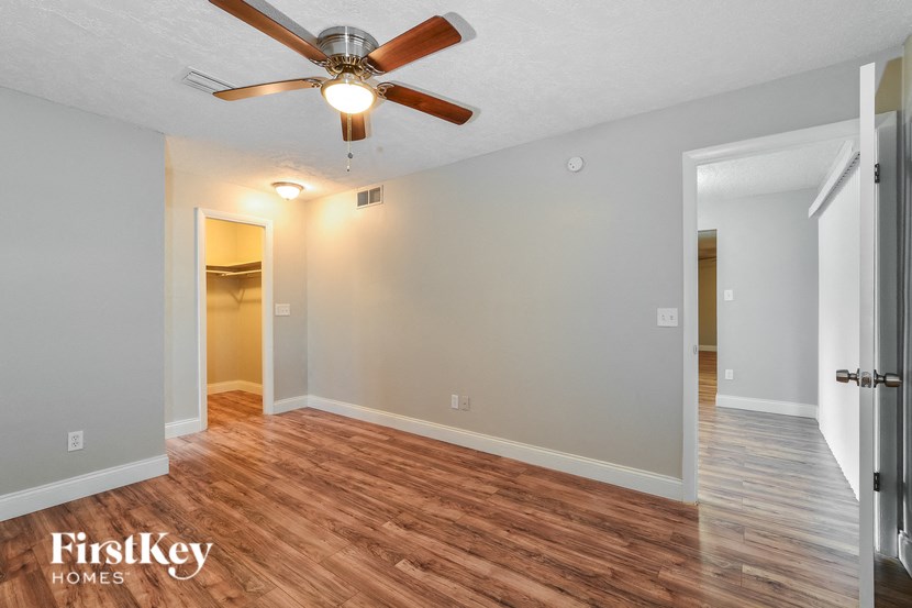 the living room of an empty house with a ceiling fan