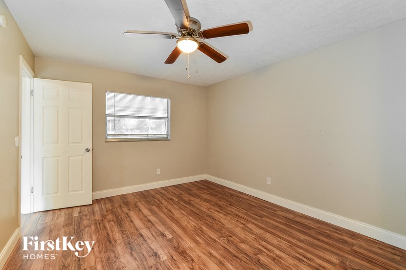 the living room of an empty house with a ceiling fan
