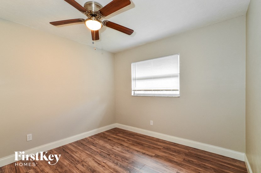 the living room has a ceiling fan and wood flooring