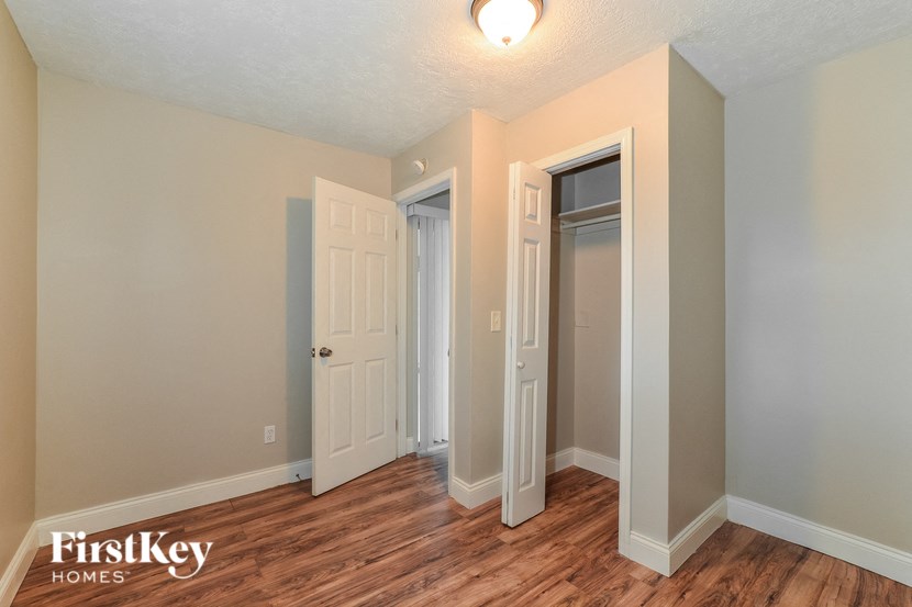 a bedroom with a hard wood floor and two closets