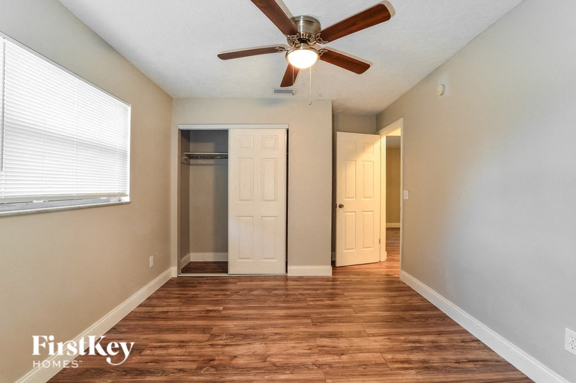 an empty room with a ceiling fan and a closet