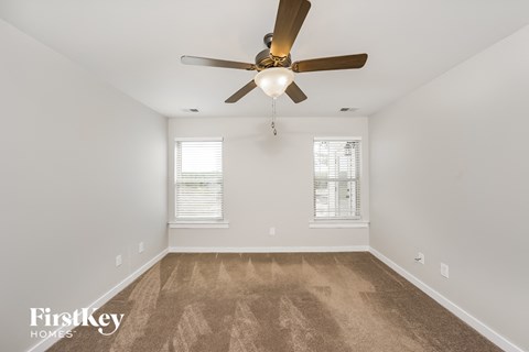 the living room is spacious and clean with a ceiling fan