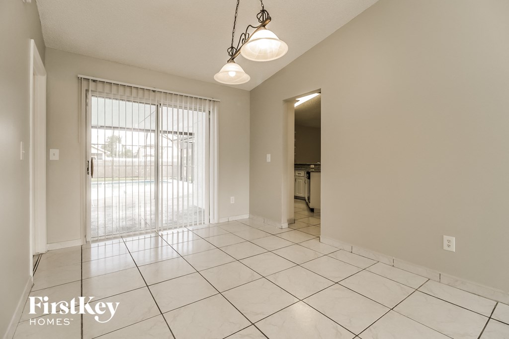 A spacious room with a sliding glass door leading to a balcony.