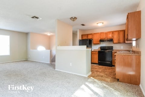 A kitchen with wooden cabinets and a black oven.