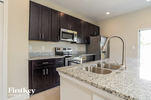 a kitchen with granite counter tops and black cabinets