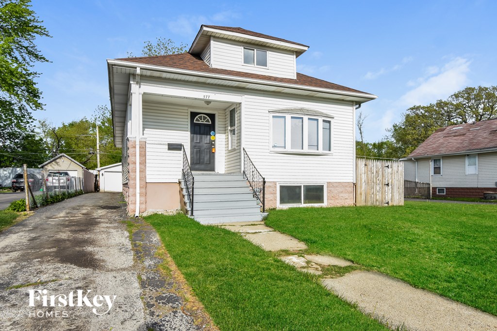 A house with a white siding and a brown roof is for sale.
