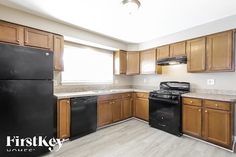 A kitchen with wooden cabinets and black appliances.