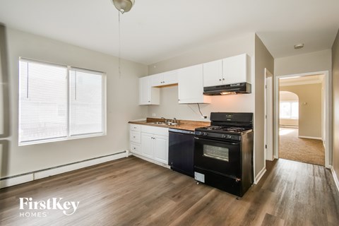 A modern kitchen with a black oven and white cabinets.