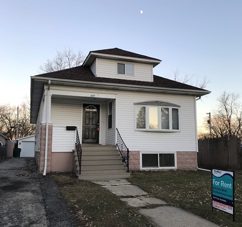 A house with a For Rent sign in front.