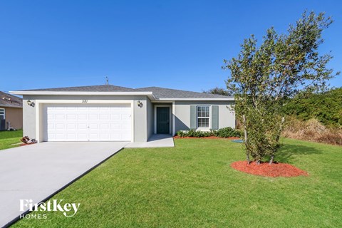a home with a white garage door and a lawn