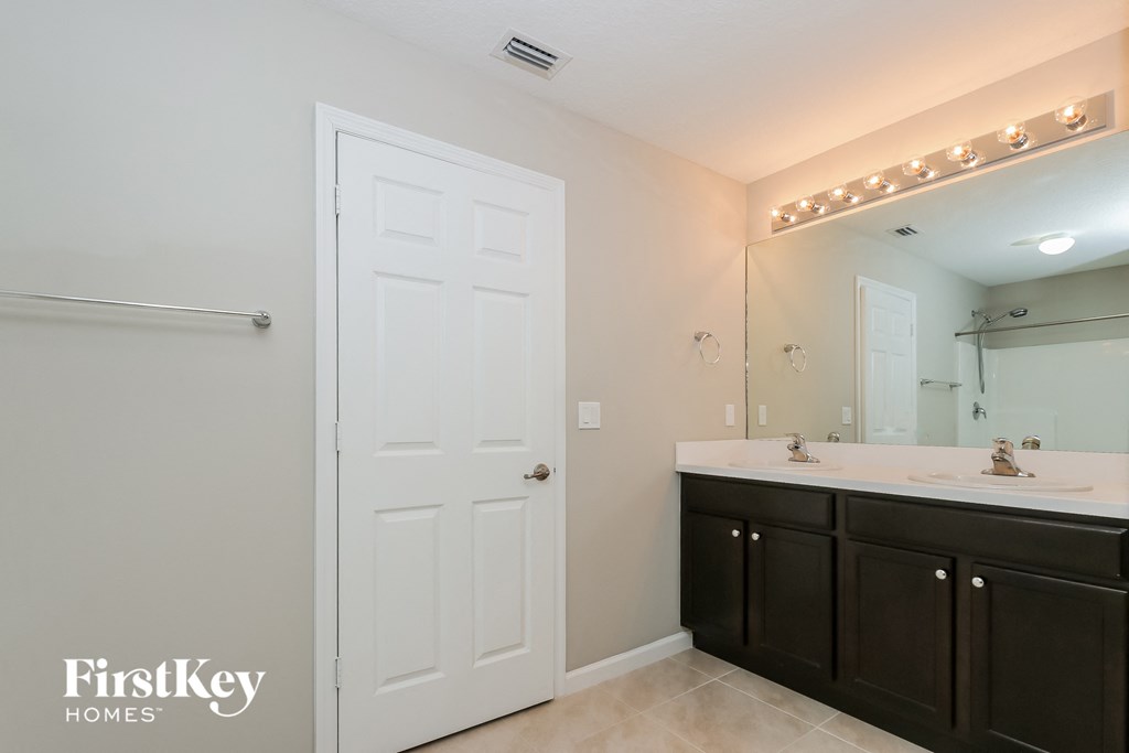 a bathroom with two sinks and a large mirror