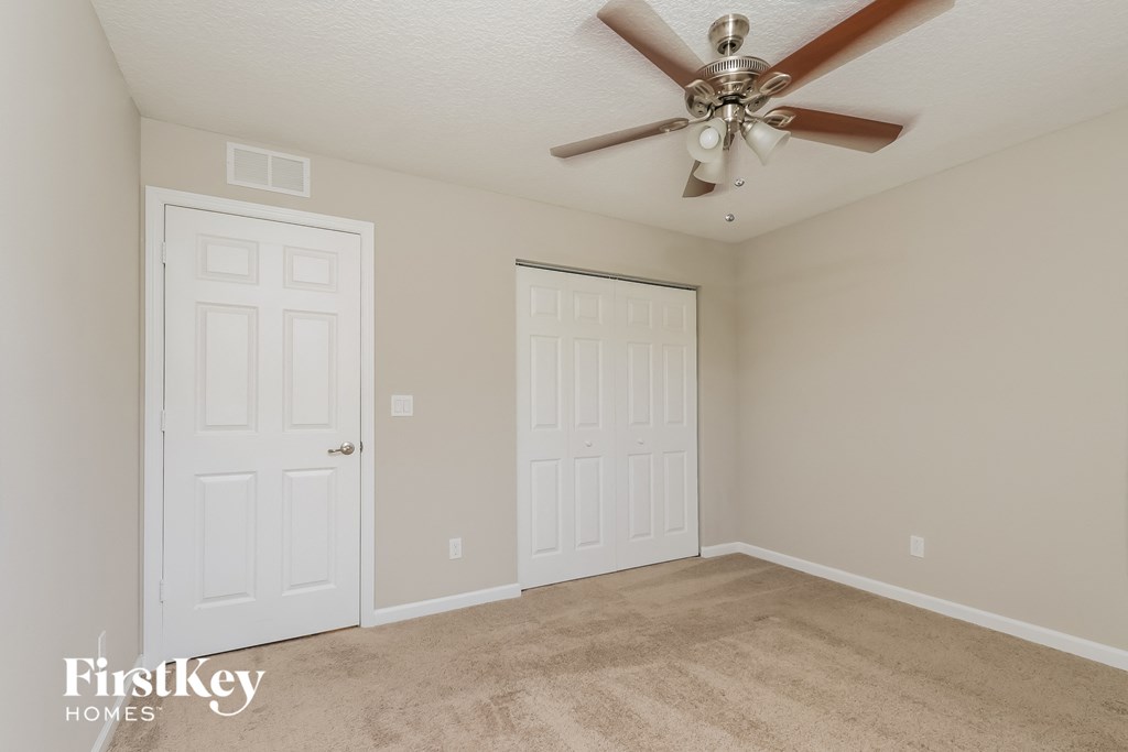 a bedroom with two closets and a ceiling fan