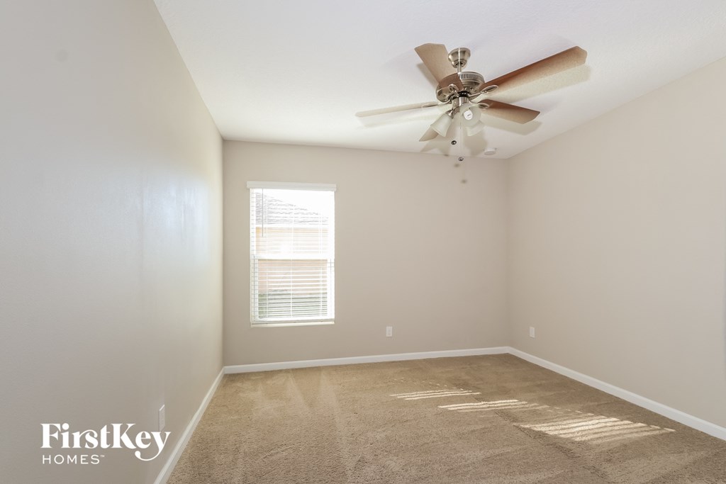 a bedroom with a ceiling fan and a carpeted floor