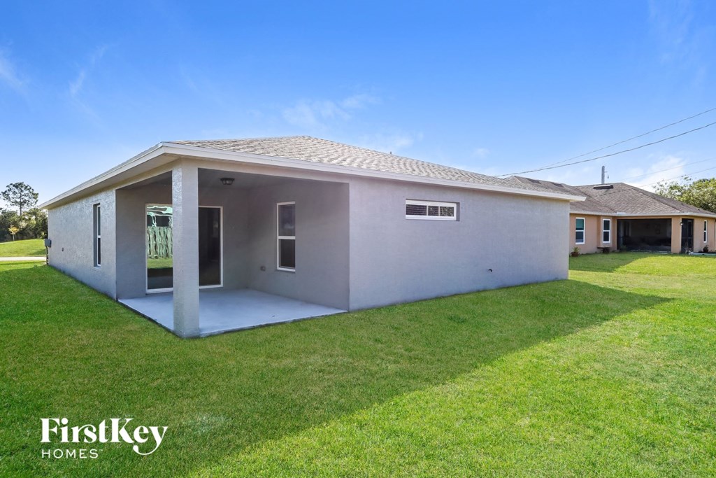 a small white house with a grass yard and a lawn