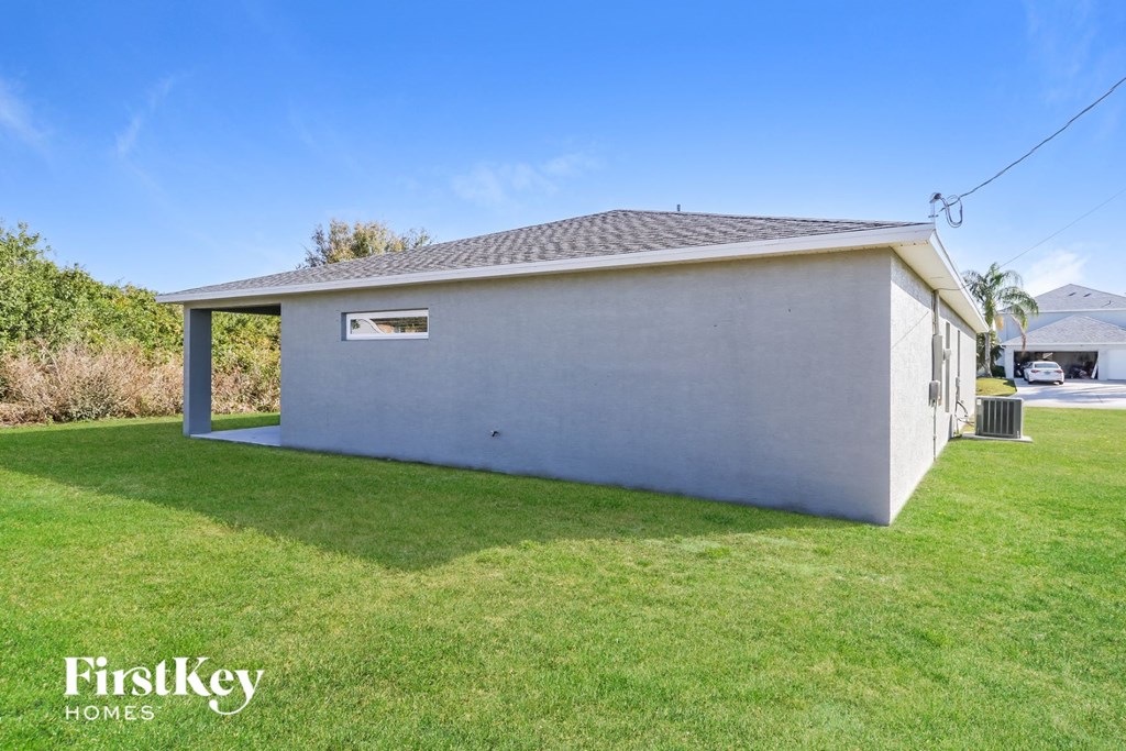 a small white house with a grass yard and a garage