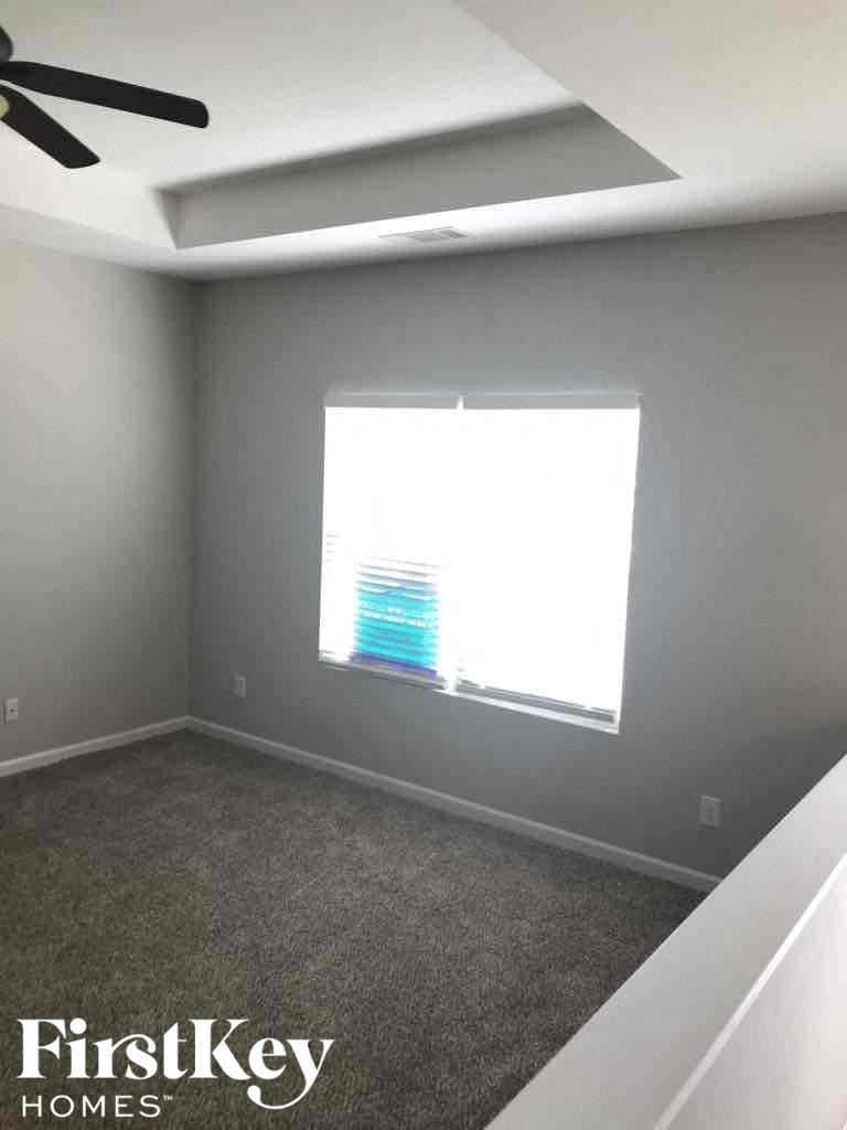 A room with a window and a ceiling fan.