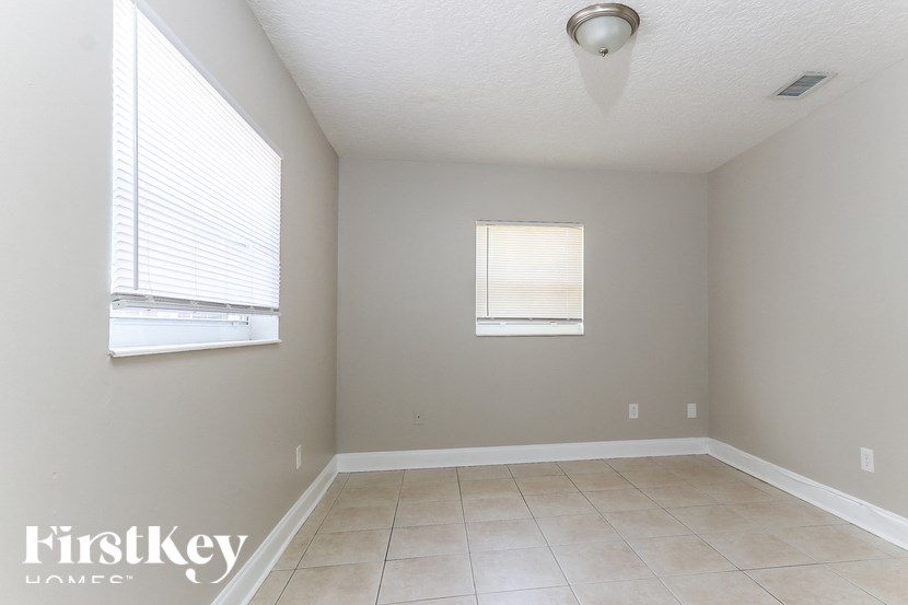 A room with a window and a tiled floor.