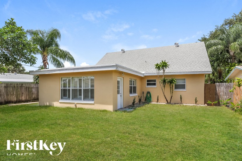A house with a lawn and a tree in front of it.