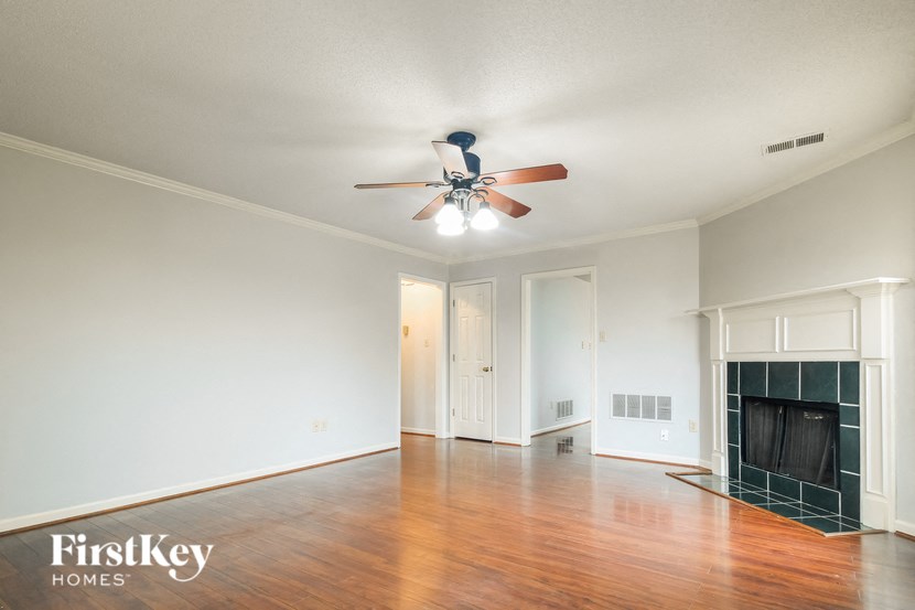 a living room with a ceiling fan and a fireplace