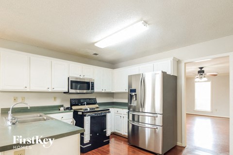 a kitchen with white cabinets and stainless steel appliances