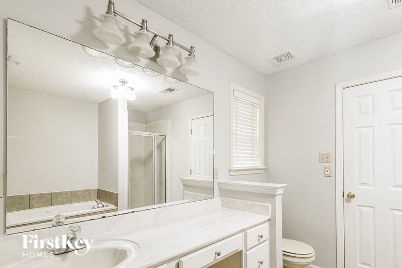 a bathroom with a large mirror and a sink and a toilet