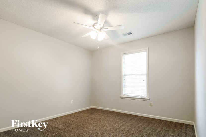 a bedroom with a ceiling fan and a window