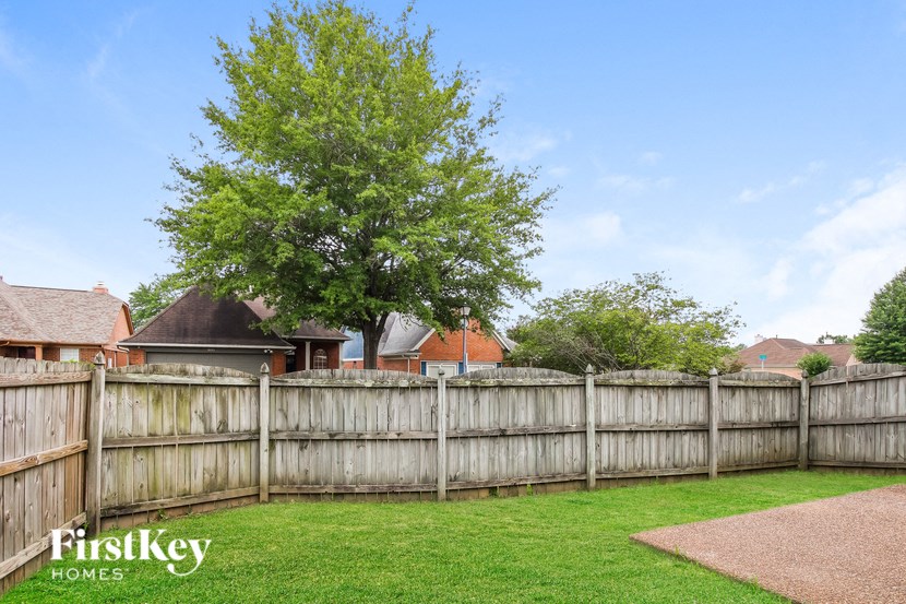 a wooden fence in a backyard in front of a house
