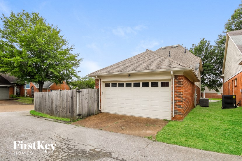 a white garage door in front of a brick house