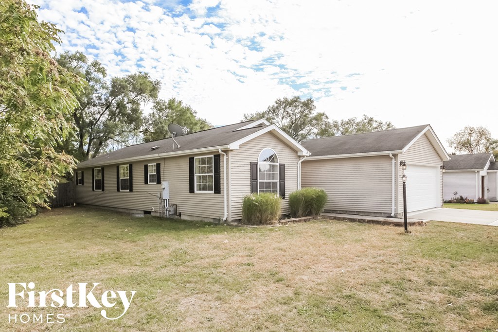 the front view of a white house with a yard and a garage