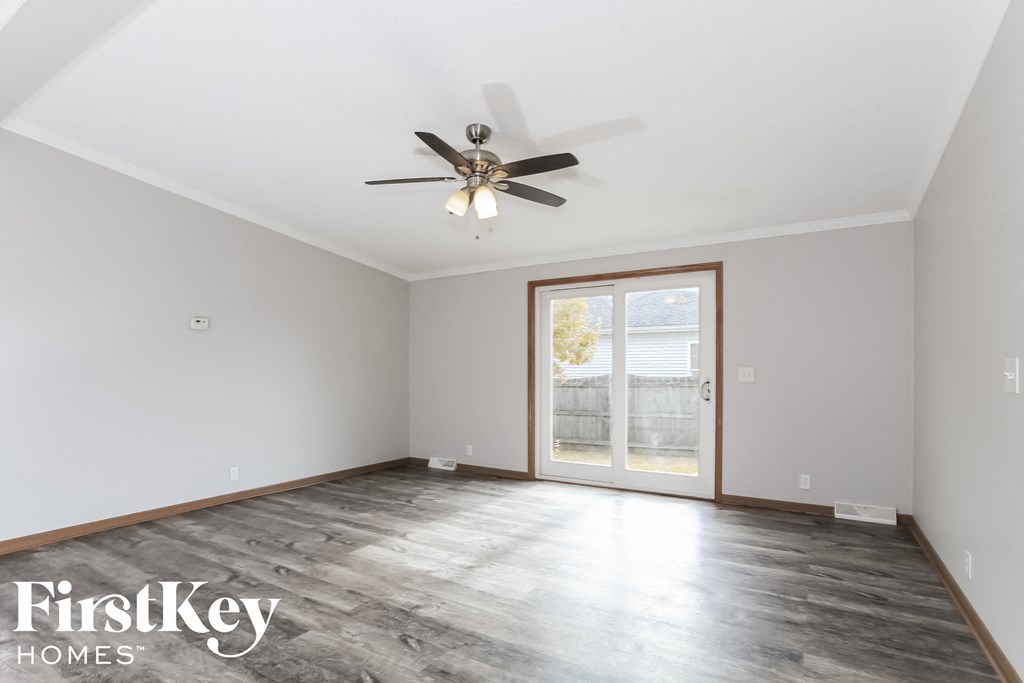 a living room with a ceiling fan and a door to a patio